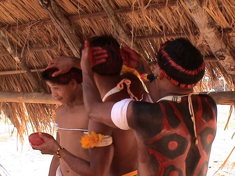 Men prepairing themselves for a dance in the central (‘men's’) hut