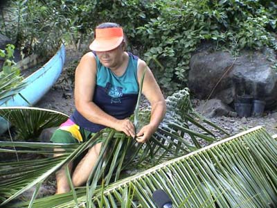 Woman plaiting coconut leaves