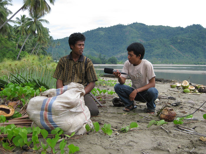 Winarno interviewing a coconut farmer on his work