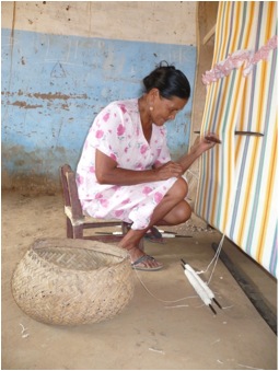 A Baure woman weaving a hammock