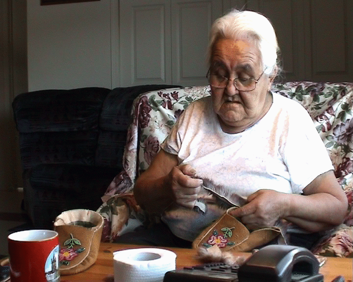 A woman making moccassins