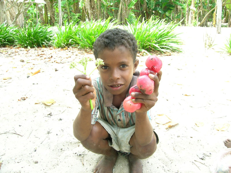 kid outside showing plants